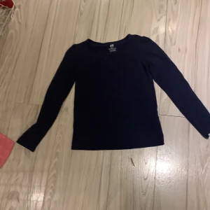 Svart långärmad tröja från H&M - Säljer en enkel och stilren svart långärmad tröja från H&M. Perfekt för lager-på-lager eller som den är. Passar till många olika outfits och tillfällen.