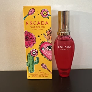 Escada Flor del Sol Eau de Toilette - Oanvänd Limited edition Escada Flor del Sol Eau de Toilette i en livlig röd flaska med silverfärgad kork. Flaskan rymmer 30 ml av denna doft.