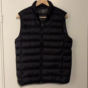 Svart dunväst från Uniqlo - Säljer en svart Ultra Light Down dunväst från Uniqlo. Västen är lätt och smidig med dragkedja framtill. Perfekt för lager-på-lager under kyliga dagar. Passar både för höst, vår och sena sommarkvällar. Nypris 600kr. MVH Elias🙌🏼