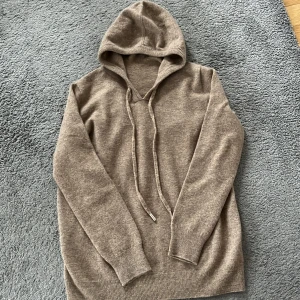 Beige hoodie kashmere/merinoull - Säljer en supermjuk beige hoodie i kashmir. Den har långa ärmar och en klassisk huva med dragsko. Perfekt för kyliga dagar när du vill vara både bekväm och stilren. Passar till det mesta i garderoben!  Aldrig använd, helt ny.