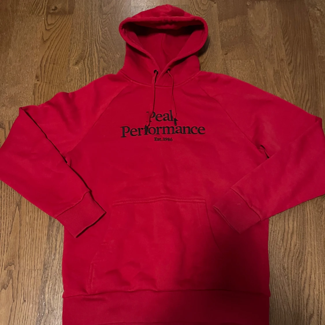 Röd hoodie från Peak Performance