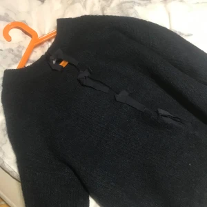 Svart tröja med knytband - Mysig svart tröja med knytband framtill. Perfekt för kyliga dagar med sin mjuka och varma känsla. En stilren design som passar till många olika outfits.