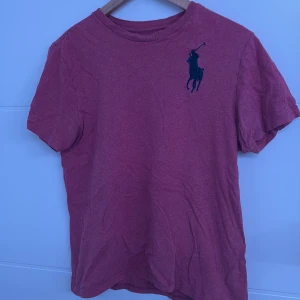 Rosa/vit ralph lauren t shirt  - En skön och fin ralph lauren t shirt, säljer på grund av att jag har växt ur den, den är i Storlek S och passar Xs. Den har andvänts ett par gånger men är ganska ny på utsidan, den tvättas innan köp av mig 