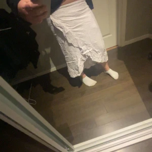 Vit o lila blommig långkjol  - Säljer en vit långkjol från Kappahl med volangdetaljer. Den är i bra skick och inga synliga skador eller liknande jag köpte kjolen 2022 skulle jag tippa på för runt 250-300 