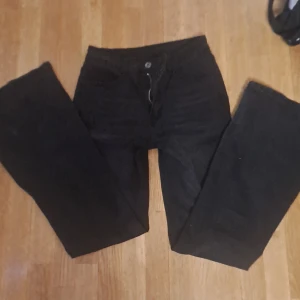 Svarta jeansbyxor - Snygga svarta jeansbyxor med dragkedja och knapp framtill. Byxorna har en klassisk femficksdesign och är tillverkade i en bekväm blandning av bomull, polyester och spandex för extra stretch. 