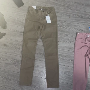 Beige chinos - Snygga beige chinos med normal passform och midwaist. Perfekta för en stilren look. De har knappar och dragkedja framtill.