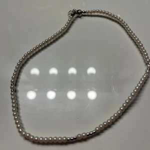 Pärlhalsband, armband och örhängen  - Elegant pärlhalsband med vita pärlor och silverdetaljer, samt ett matchande armband med större pärlor i en mer rosa nyans. Halsbandet är aldrig använt och armbandet har använts någon gång. Samt helt nya eleganta pärlörhängen i olika storlekar. Allt för 140 kr, Armbandet säljer jag för 100 kr då det är ett ganska unikt med rosefärgade pärlor ☺️