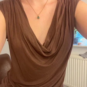 Brun top - Top från Zara med draped neckline. Bra skick, inte nopprig. Finns möjlighet till att mötas upp.