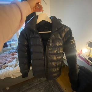Svart jacka peak performance  - Snygg svart dunjacka med huva och dragkedja. Dragkedjan är inprincip sönder men går att laga.  Skriv för fler bilder, finns små defekter. Storlek 140, passar xxs 