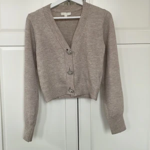 Beige kofta med dekorativa knappar - I bra skick.