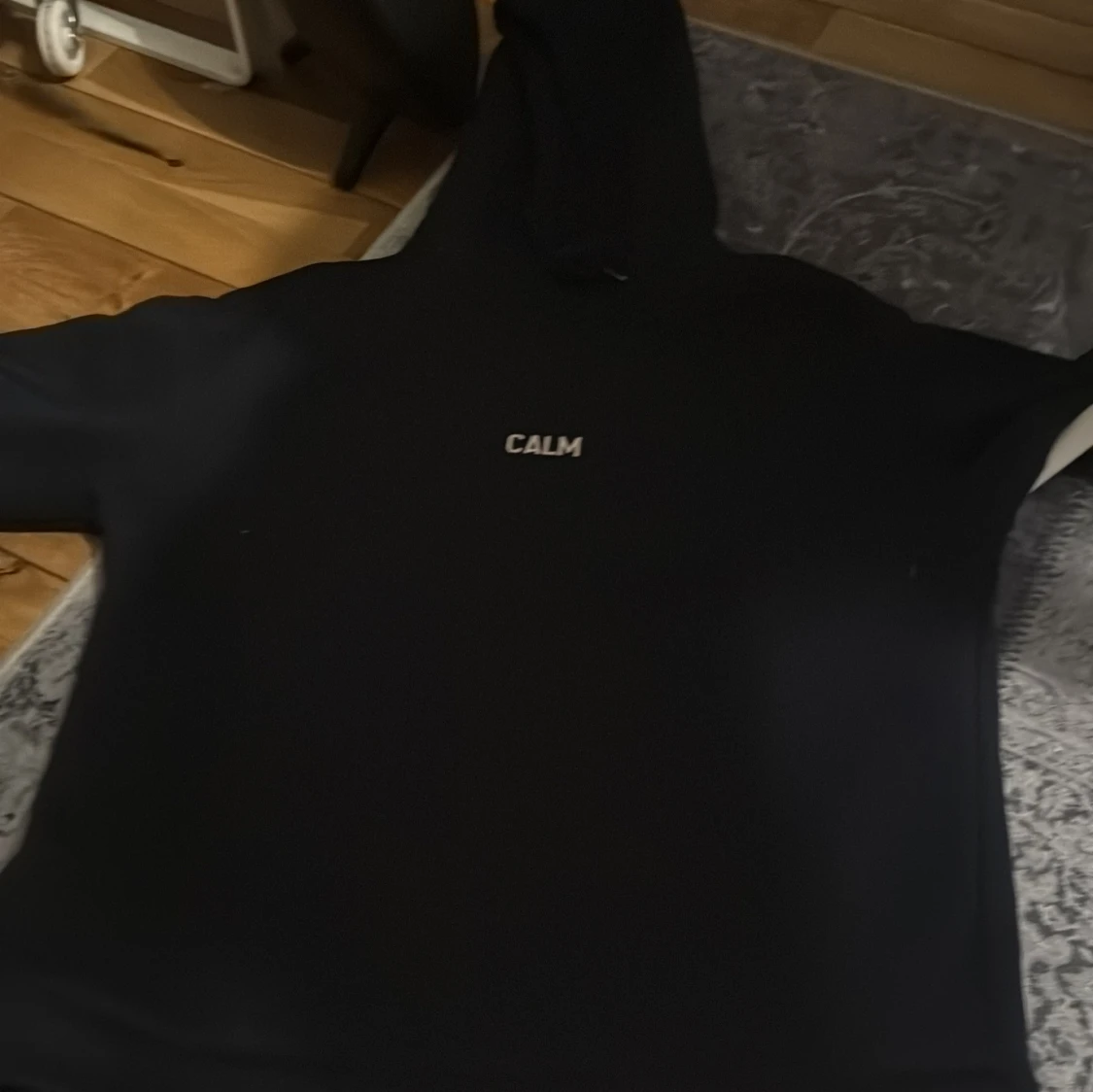 Svart hoodie med texten 'CALM'