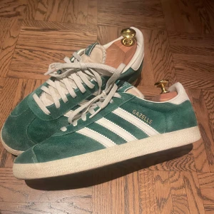 Gröna Adidas Gazelle sneakers - Snygga gröna Adidas Gazelle sneakers i mocka med vita detaljer och snörning. 