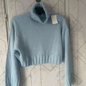 Ljusblå stickad polotröja från H&M - Nyköpt ljusblå stickad polotröja från H&M. Tröjan är croppad med långa ärmar och har en ribbad polokrage samt ribbade muddar. Nypris ca 170kr 