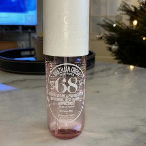 Brazilian Crush Cheirosa 68 Perfume Mist - Fräsch och exotisk doftmist med noter av brasiliansk jasmin och rosa drakfrukt. Flaskan är genomskinlig med rosa ton och har en vit spraykork. Perfekt för en tropisk känsla. Är använd ett par gånger 