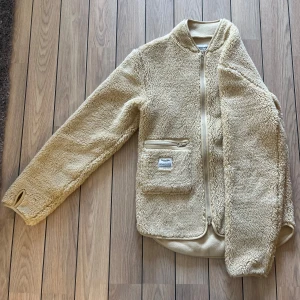 Beige fleecejacka Resteröds  - Fleecen är helt ny och oanvänd. Den är från märket Resteröds. Den är tyvärr för stor för mig. Supermjuk och skön! Den är rätt stor för att vara i storlek XS, då det är herrstorlek.