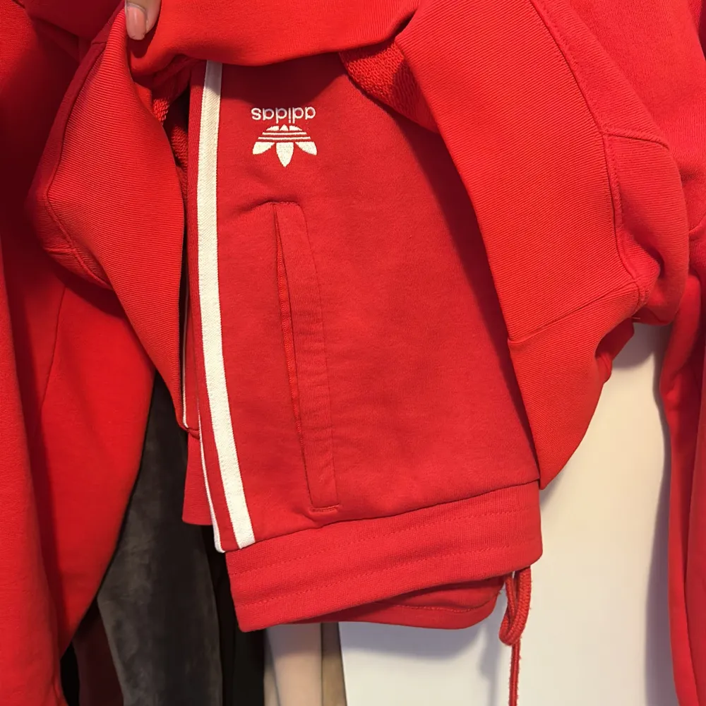 Adidas mjukis set i röd färg. Hoodien  i storlek 34 (XS) och byxorna i storlek S men skulle säga att de är som XS också. Aldrig använt utomhus, endast en gång här hemma…. Hoodies.