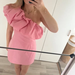 Hm klänning  - Rosa volang klänning från hm! Använd en gång, dragkedja i sidan!