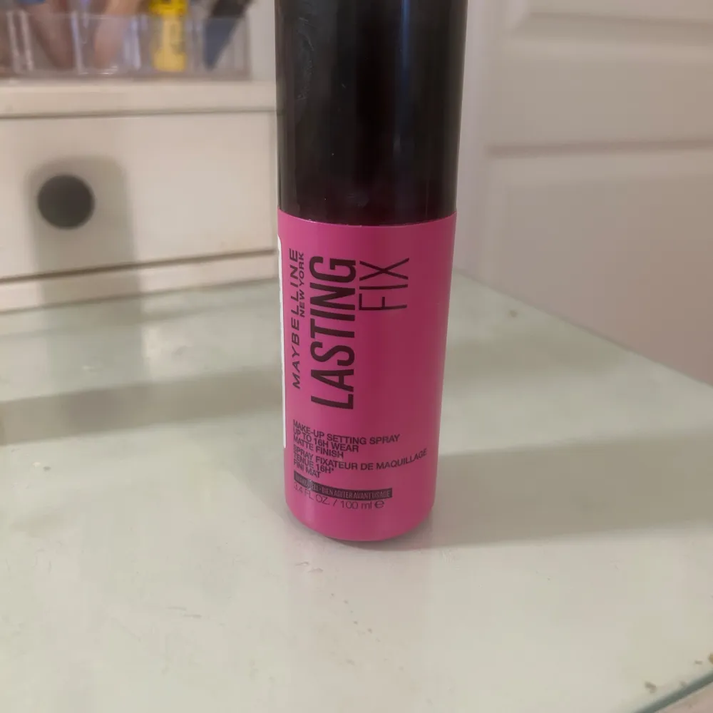 Säljer en Maybelline Lasting Fix Face Mist som hjälper till att hålla sminket på plats hela dagen. Den kommer i en snygg rosa flaska med svart lock. Perfekt för att fräscha upp looken och ge en matt finish. Använd den som sista steget i din sminkrutin för bästa resultat!. Skönhet.