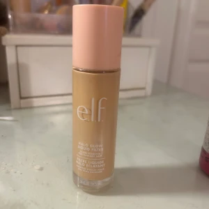 e.l.f. Halo Glow Liquid Filter - Säljer en e.l.f. Halo Glow Liquid Filter som ger en fantastisk glow till huden. Den kommer i en smidig flaska med en ljusrosa kork. Perfekt för att få en strålande och jämn hudton. Använd den ensam eller under din foundation för extra lyster.