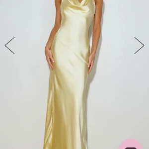 Långklänning i satin - Säljer en elegant långklänning i satin. Klänningen har en vacker draperad halsringning och är ärmlös, vilket ger en stilren och sofistikerad look. Perfekt för festliga tillfällen eller en glamorös kväll.