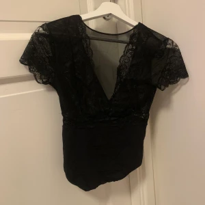 Spets topp - Säljer denna snygga spets toppen som från början var en body men jag klippte av delen där nere så ❤️ på framsidan är den urringad och har mesh tyg mellan brösten och på ryggen är den öppen och format som ett V. Kom priv för bilder på 😊