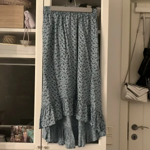 Blå blommig kjol från Aware by Vero Moda - Säljer en söt blå kjol med blommigt mönster från Aware by Vero Moda. Kjolen har volangdetaljer i nederkant och en bekväm resår i midjan. Perfekt för en somrig look! 🌸kom privat för fler bilder 🦋