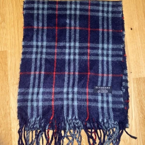 Burberry Halsduk - Tjena! Säljer nu denna snygga mörkblåa Burberry halsduk i 100% cashmere. Den är 150 cm lång och i mycket bra skick!  Hör gärna av dig om du har några frågor eller vill se fler bilder!