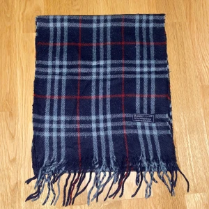 Burberry Halsduk - Tjena! Säljer nu denna snygga mörkblå Burberry halsduk i 100% lammull. Den är 150 cm lång och i mycket bra skick!  Hör gärna av dig om du har några frågor eller vill se fler bilder!