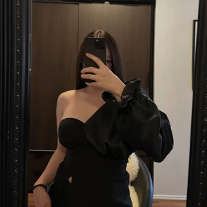 Topp - Elegant svart oneshoulder klänning med en dramatisk puffärm och knapprad på sidan. Perfekt för en stilfull kväll. Klänningen har en figurnära passform som framhäver silhuetten.🥰🥰🥰