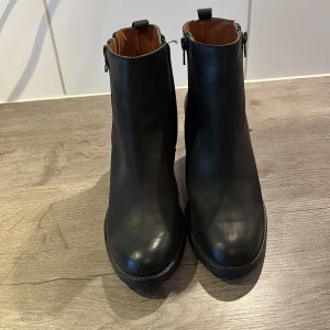Svarta boots med dragkedja - Snygga svarta boots i skinn med dragkedja på sidan och klack. Perfekta för en stilren look. De har en rund tå och är enkla att matcha med olika outfits. Oanvända.