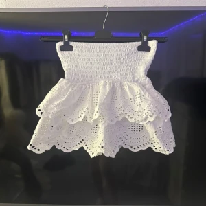 Vit kjol med volanger  - Säljer en söt vit kjol med volangdetaljer. Kjolen har en elastisk midja för en bekväm passform. Den går inte att köpa längre så säljer därför för 480 💕