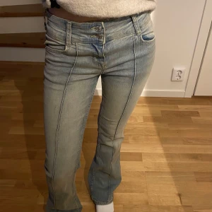 Ljusblå jeans från Bershka - Snygga ljusblå jeans från Bershka med fyra fickor och två knappar. De är lågmidjade bootcut i modellen och har pressveck på framsidan. Andvända ett fåtal gånger! Storlek 34 men passar även 32.