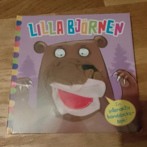 Lilla Björnen - En interaktiv handdockbok för barn med en söt björn på omslaget. Boken har färgglada bokstäver och en rolig design som engagerar barnen. Perfekt för högläsning och lek. Fortfarande inplastad.