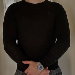 Svart ribbstickad tröja från Morris - Stilren svart kabelstickad tröja från Morris i storlek S. Tröjan är tillverkad av 100% merinoull och är i ett grymt 10/10 skick! Den har inga märken eller defekter och knappt heller några tecken på anvädning. Den är perfekt för det lite kyligare dagarna, och ger dig en elegant touch på sin outfit!🎩 nypris runt 1600-1800👌