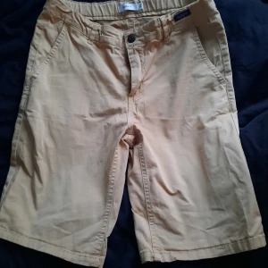 Beigea shorts - Shorts från name it. Dragkedja. Dragsko i midjan. 