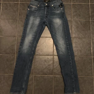 Mörkblå Replay Grover - Ett par Replay Jeans i fint skick. Jeansen har väldigt bra kvalite och en skön tvätt. Tyvärr så har lappen på baksidan gått sönder men det är inget som syns vid användning. Tveka inte att höra av dig vid frågor. :)