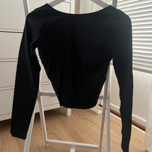 Svart långärmad topp från Hollister - Säljer en stilren svart långärmad topp från Hollister. Toppen är djup i ryggen. 