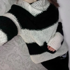 Randig stickad tröja från GILL - Säljer en mysig randig stickad tröja från GILL i svart och vit. Tröjan har en stor krage och långa ärmar, perfekt för kyliga dagar. Den är både stilren och bekväm, ett måste i garderoben! 🖤🤍