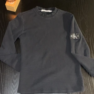  Calvin Klein tröja - Säljer en stilren svart långärmad tröja från Calvin Klein Jeans. Inga deffekter. Nypris: 1099kr. Mitt pris: 120kr. Priset kan diskuteras