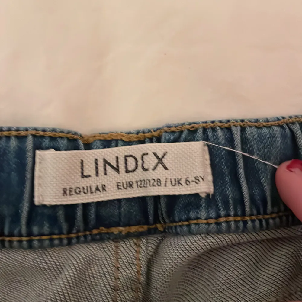 Säljer ett par blå jeansshorts från Lindex i storlek 122/128. De är lite slitna,  och dom har ingen knapp eller dragkedja.. Shorts.