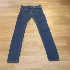 Blå skinny jeans från Replay - Säljer ett par snygga blå skinny jeans från Replay i storlek 27. De är i bra skick och har en klassisk femficksdesign med dragkedja och knapp. Perfekta för både vardag och fest! 💙