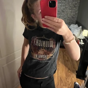 Svart t-shirt med örntryck - Säljer en svart t-shirt från H&M med ett coolt tryck av en örn och texten 'Midnight Thunder'.   