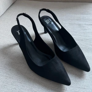 Svarta kittenklackar från XIT - Snygga svarta kittenklackar från XIT i mocka med spetsig tå och smal klack. 