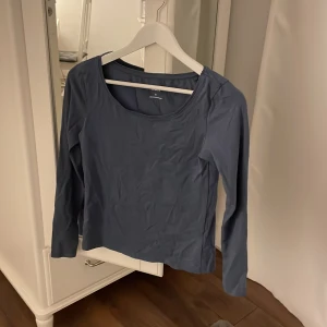 Mörkblå långärmad topp från 157 - Säljer en mörkblå långärmad topp från 157 i storlek M. Den är gjord av 95% bomull och 5% elastan, vilket gör den både bekväm och stretchig. Perfekt för vardagsbruk eller en avslappnad dag ute. Toppen har en enkel och stilren design med rund halsringning.