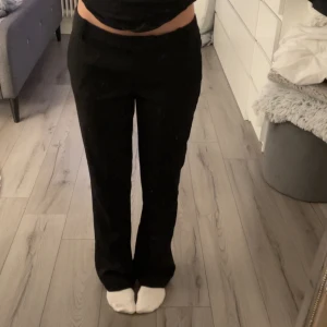 Svarta byxor från BikBok - Säljer ett par stilrena svarta byxor från BikBok i storlek 38. De har en klassisk straight passform och är perfekta för både vardag och fest. Byxorna är lågmidjade och ger en snygg siluett. Perfekta att matcha med en snygg topp eller skjorta!