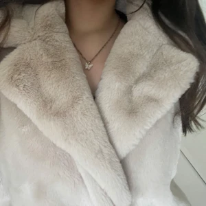 (Faux fur coat) fluffig beige/vit kappa  - Supermjuk och fluffig beige pälsjacka som är perfekt för kyliga dagar. Den har en stor krage och är i mycket bra skick. Jackan är långärmad och ger en lyxig känsla. Perfekt för både vardag och fest! #winterfashion #fluffycoat