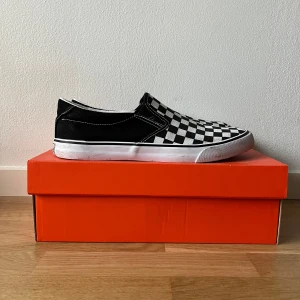 Svartvita slip-on sneakers med rutigt mönster - Säljer ett par klassiska svartvita slip-on sneakers med coolt rutigt mönster