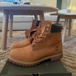 Timberland Premium 6 Inch Waterproof Boot - Säljer ett par klassiska Timberland Premium 6 Inch boots i den klassiska färgen. De är vattentäta och perfekta för höst och vinter. Skorna har snörning och en robust sula för bra grepp. De är i nytt skick och kommer i originalkartong. Storlek 44,5 men passar även 45. Nypris: 2300kr