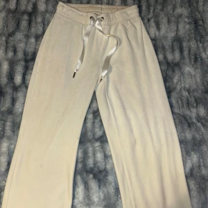Vita mjukisbyxor från Gina Tricot - Säljer ett par superbekväma vita mjukisbyxor från Gina Tricot i storlek XS. De har en elastisk midja med snörning för perfekt passform. Perfekta för mysiga dagar hemma eller en avslappnad dag ute. 🤍