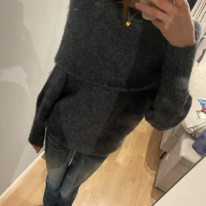 Mörkgrå stickad offshoulder tröja - Säljer en supermysig mörkgrå stickad tröja med offshoulder-design. I storlek M men har en lika dan i en annan färg i storlek S och sitter nästan exakt lika.  Perfekt för vintern eftersom den är väldigt varm och mysig